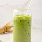 Straight on view of a glass of protein matcha latte.