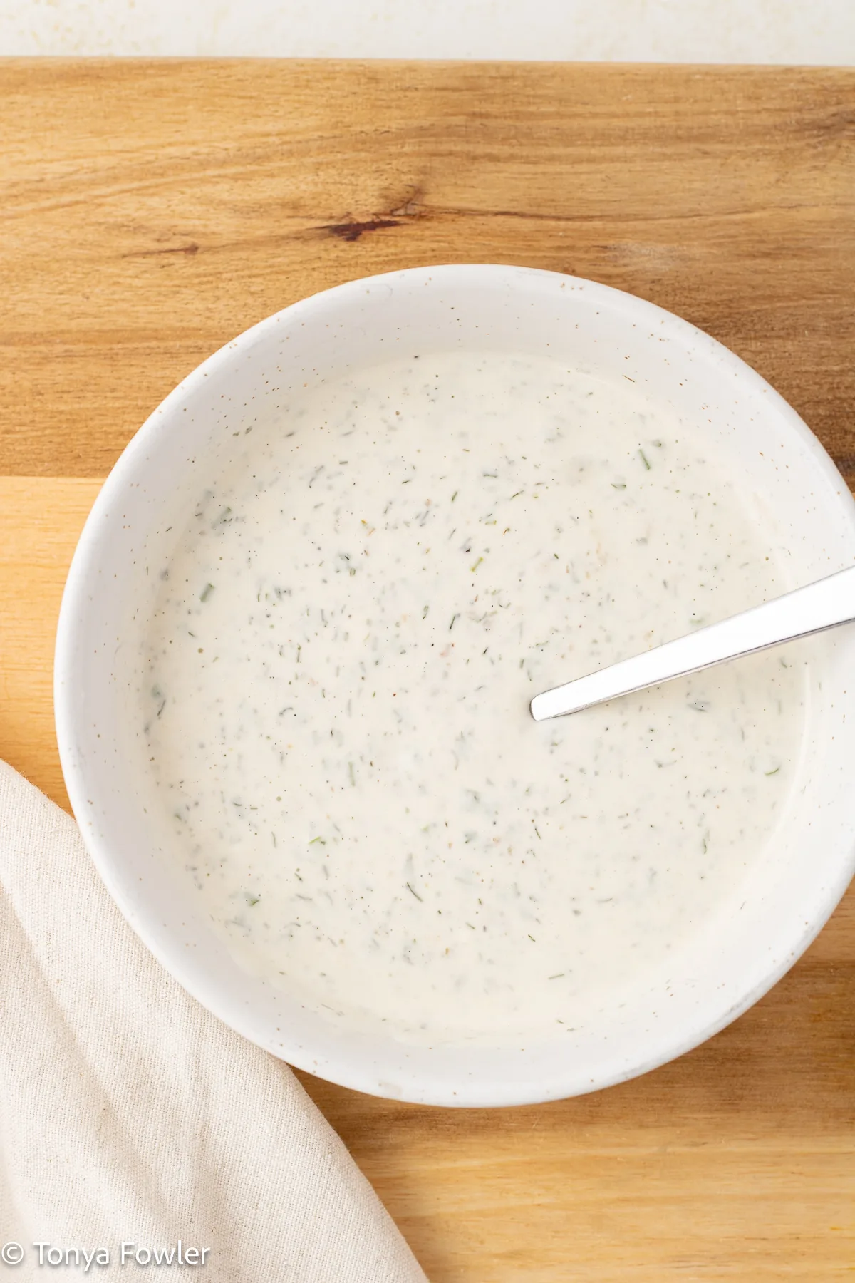 Ranch dressing in a bowl with a spoon.