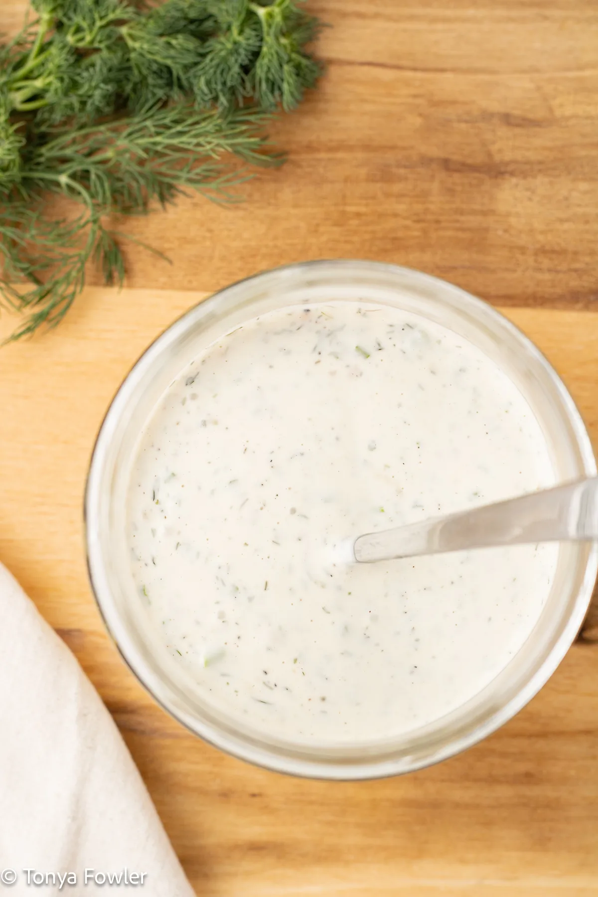 Salad dressing in a jar with a spoon.