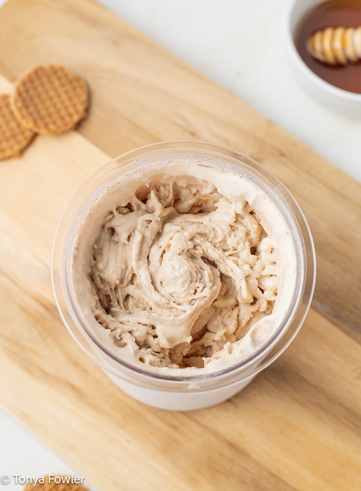 Blended honey ice cream in a pint container.