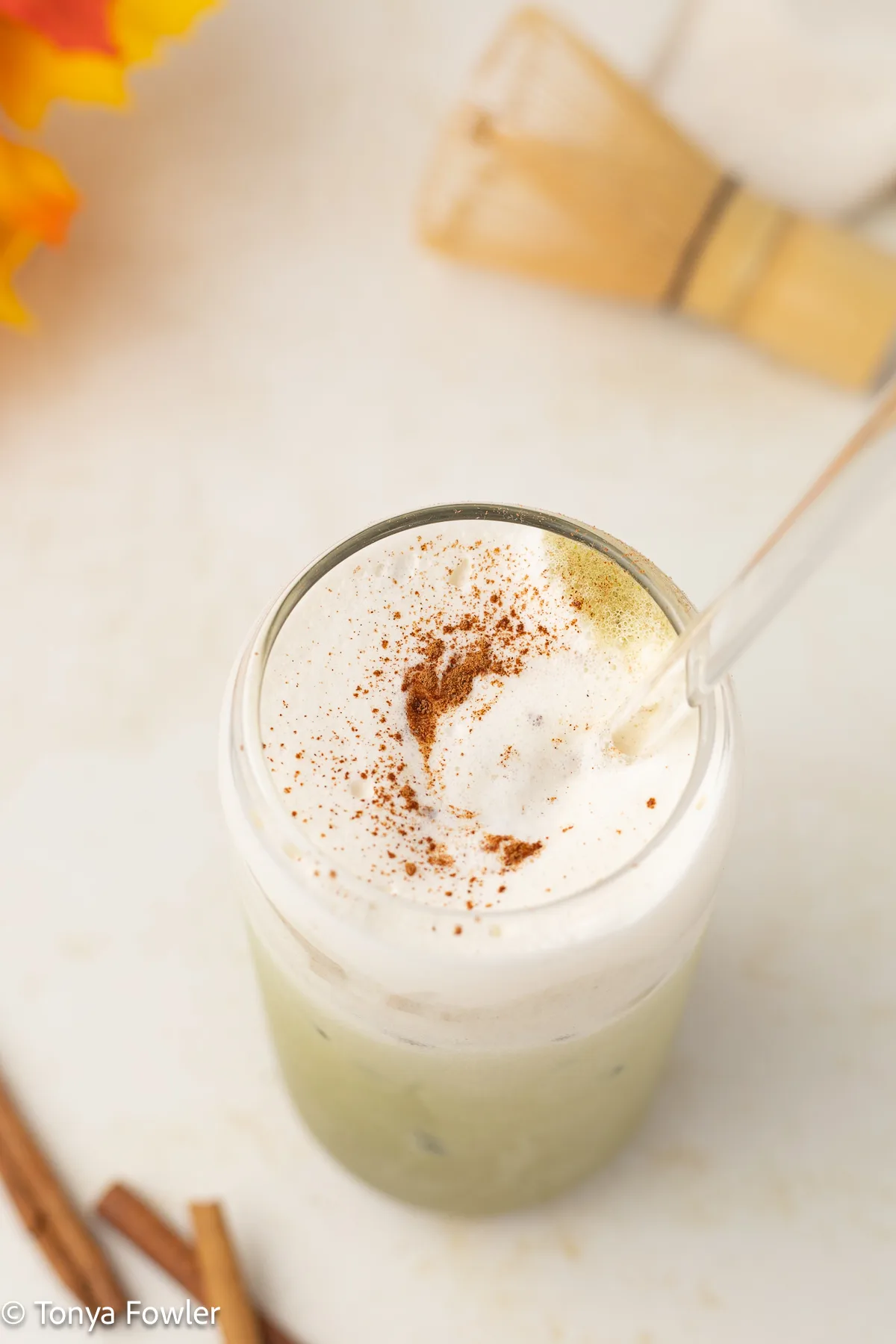 3/4 view of matcha latte topped with cold foam and ground cinnamon.