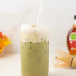 Maple cinnamon matcha latte in a glass topped with cold foam.