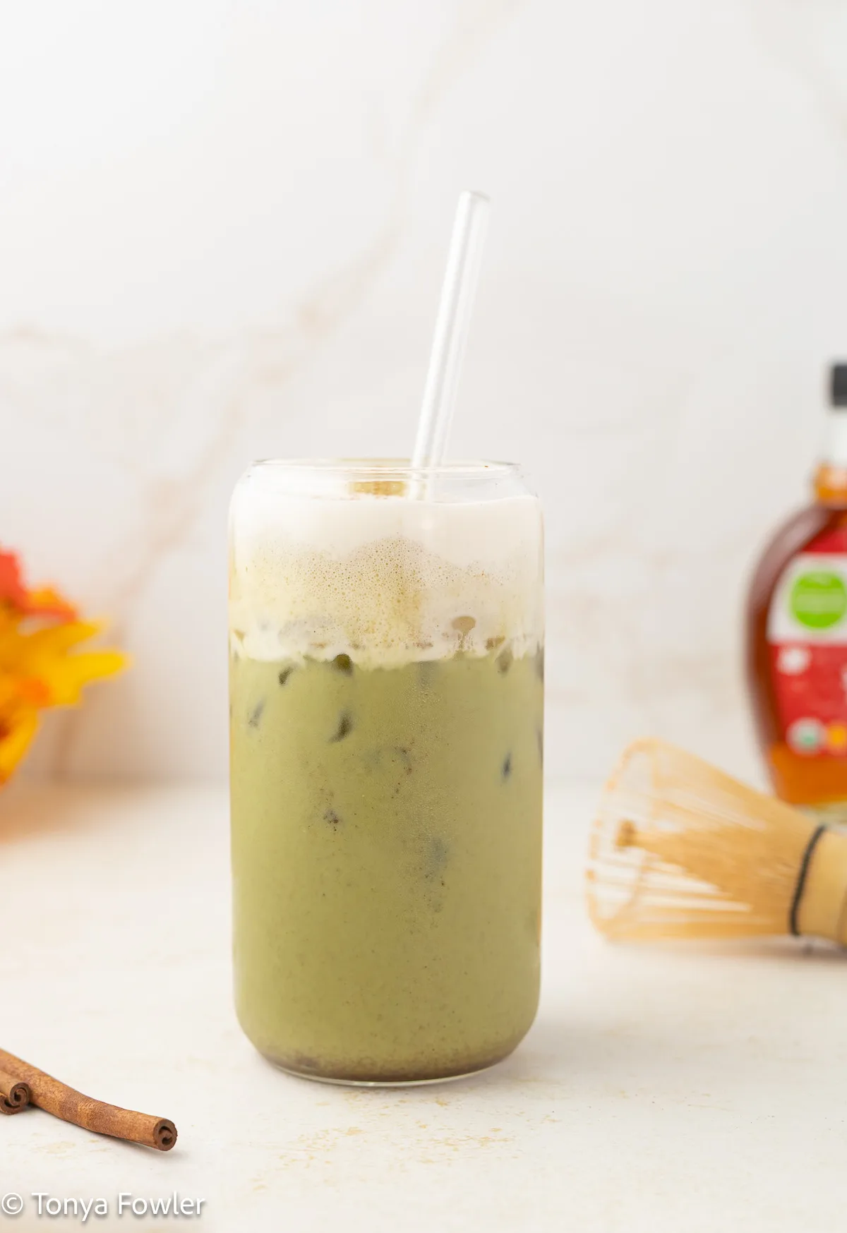 Maple cinnamon matcha latte in a glass topped with cold foam.