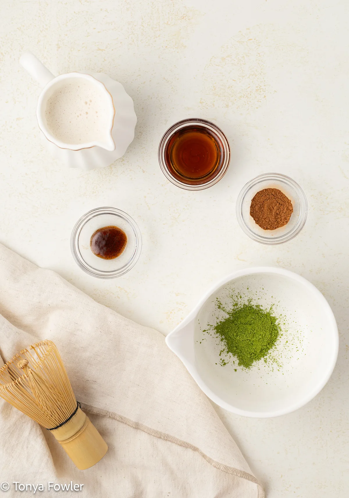 Cinnamon maple matcha latte ingredients on a table.
