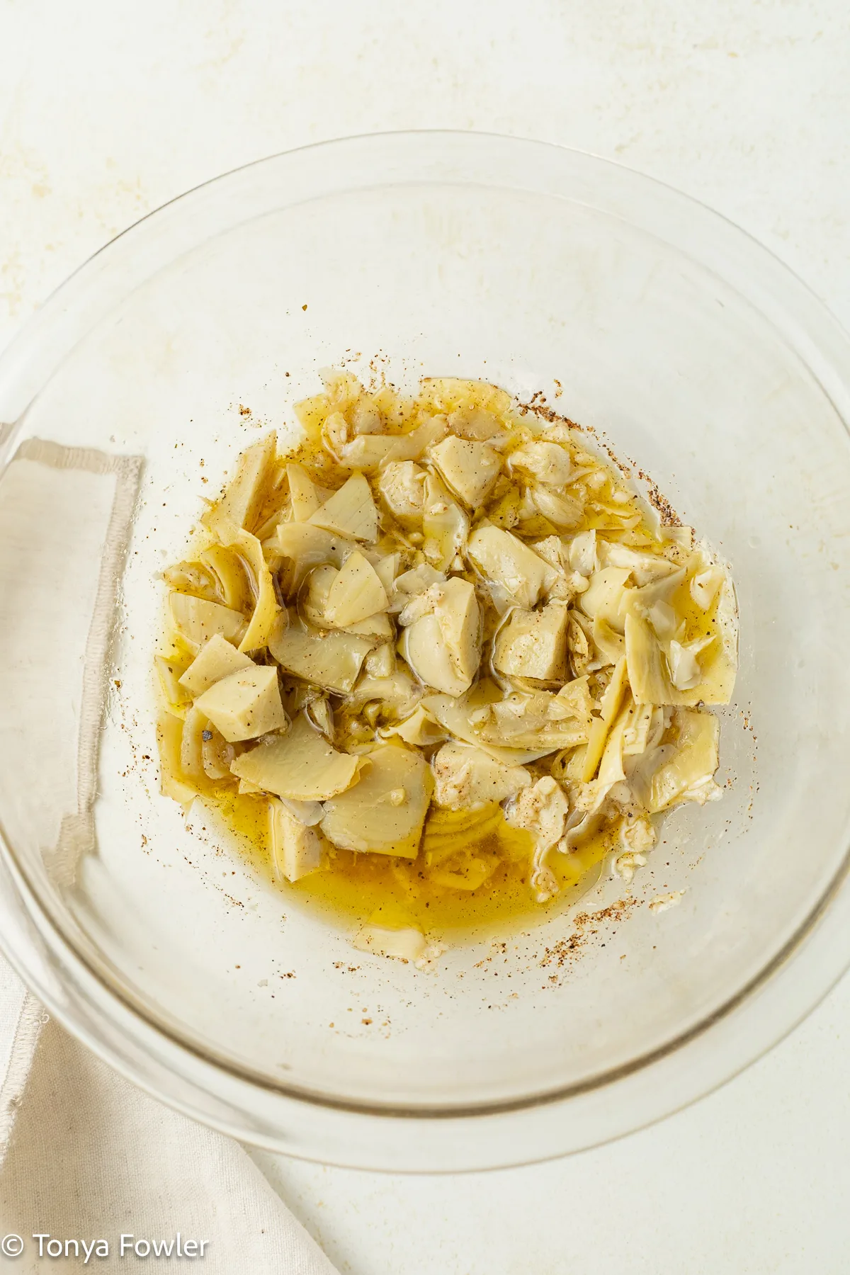 Marinated artichokes and salad dressing in a bowl. 