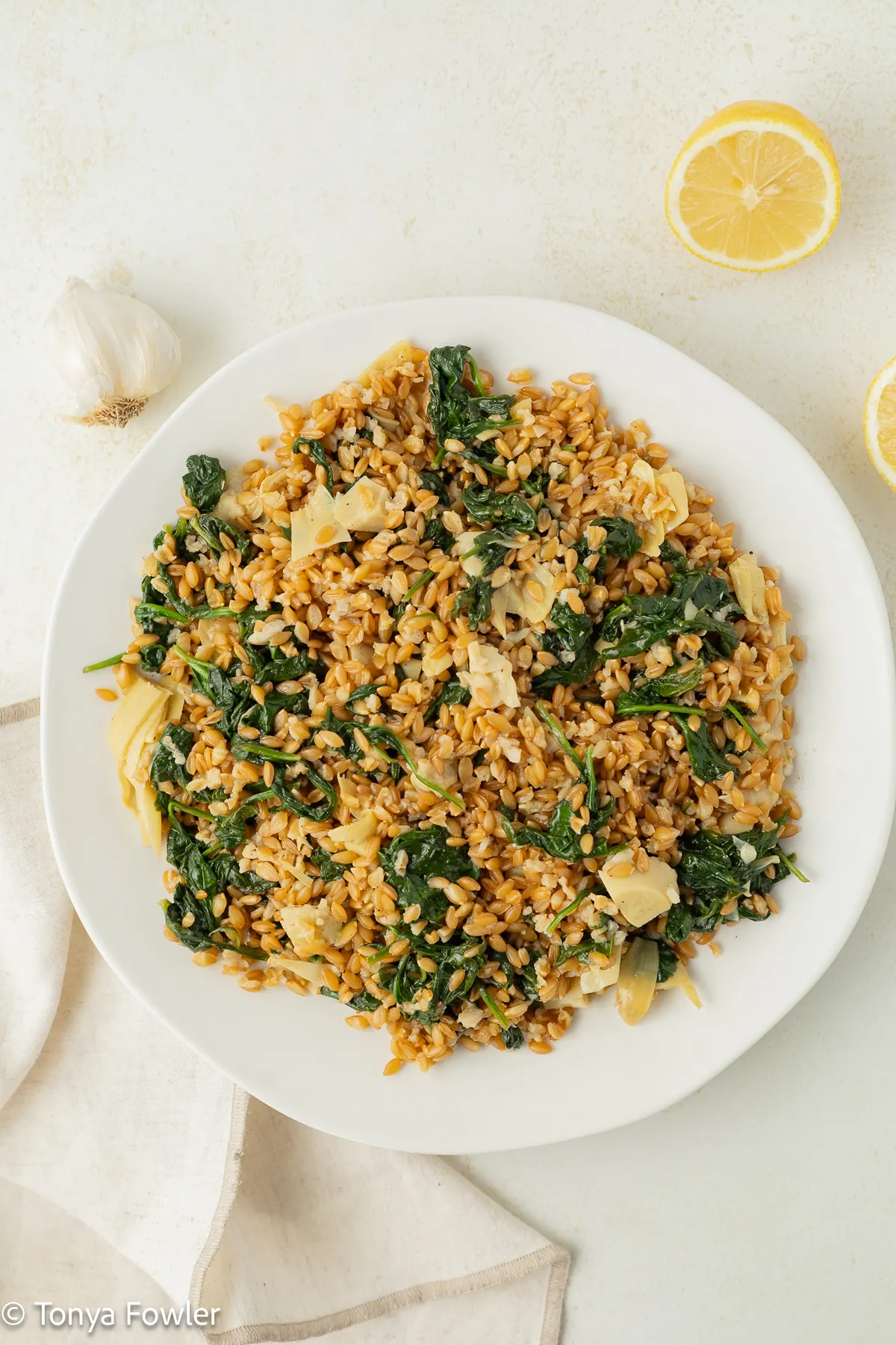 Overhead view of wheat berry spinach salad on a plate. 