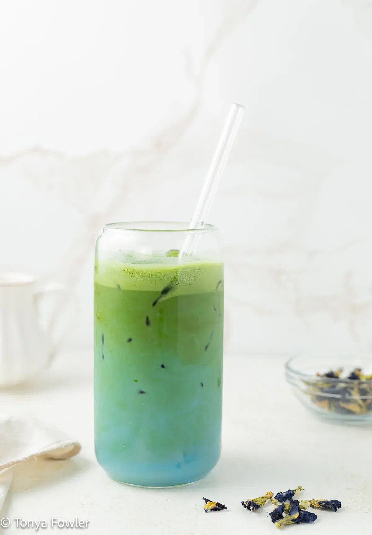 Blue green tea latte in a glass with ice.